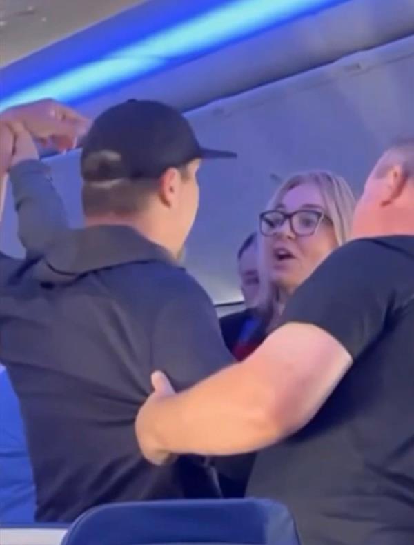 A Southwest airlines crew member is seen telling the man to back away after he landed a series of punches on the other passenger.