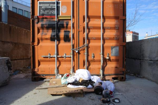 Migrants sleeping inside steel co<em></em>ntainer amidst trash piles.